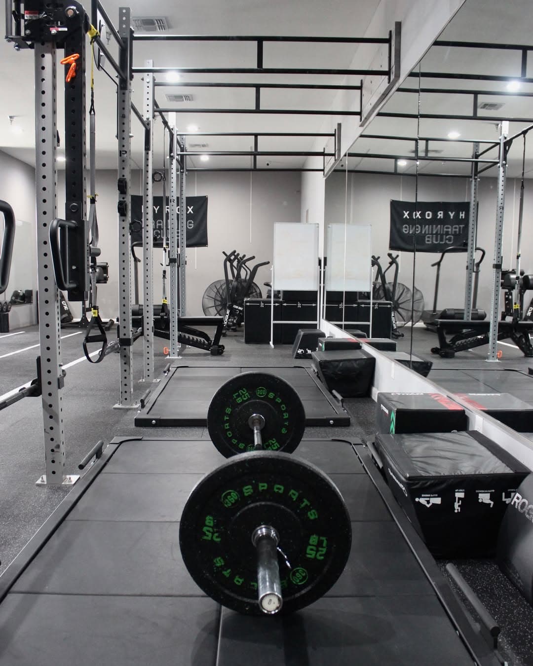 A loaded barbell on the lifting platform beside the rig at Mpower
