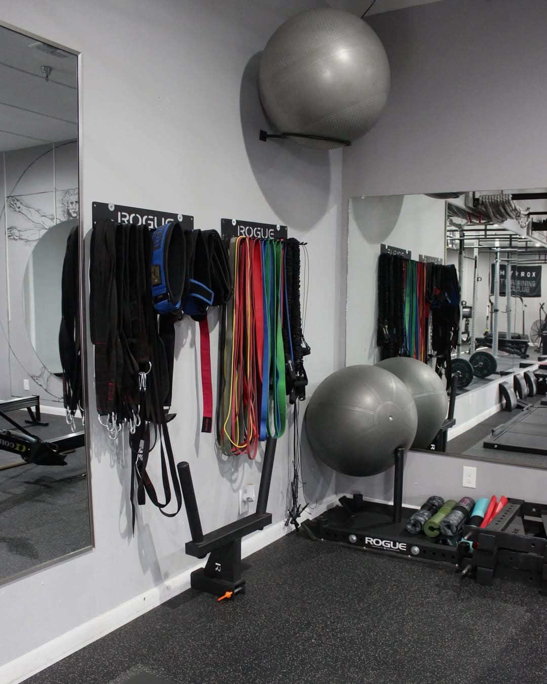 Sleds, resistance bands, and stability balls racked along the wall